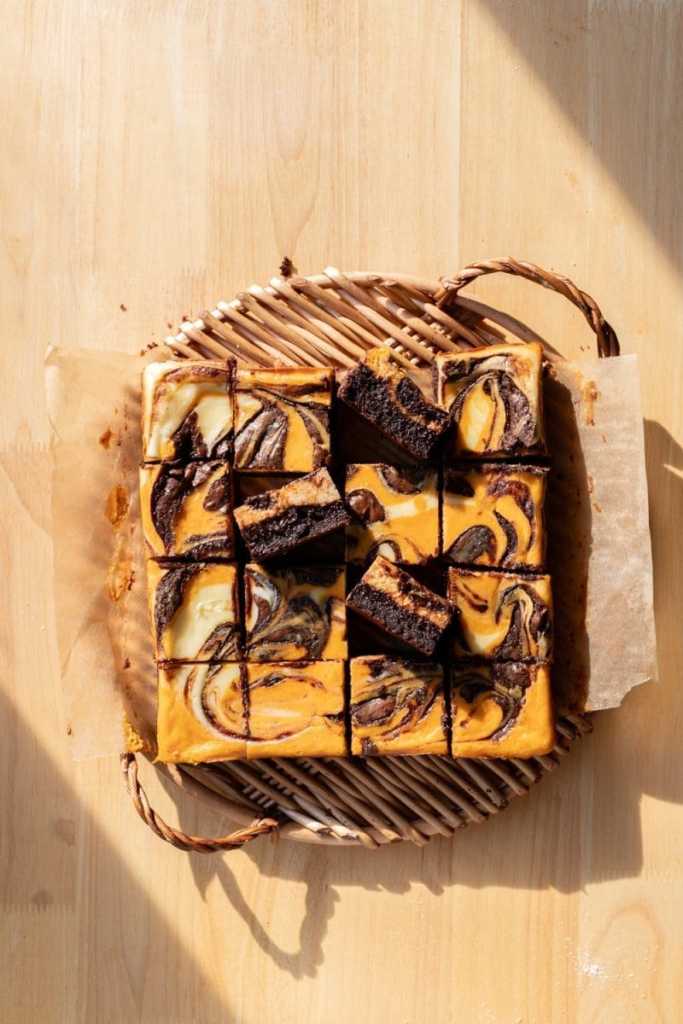 The pumpkin cheesecake brownies on a serving tray.