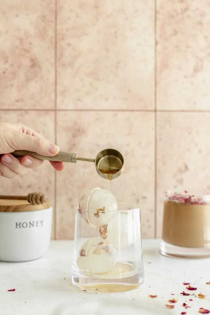 pouring the honey rose syrup into a glass