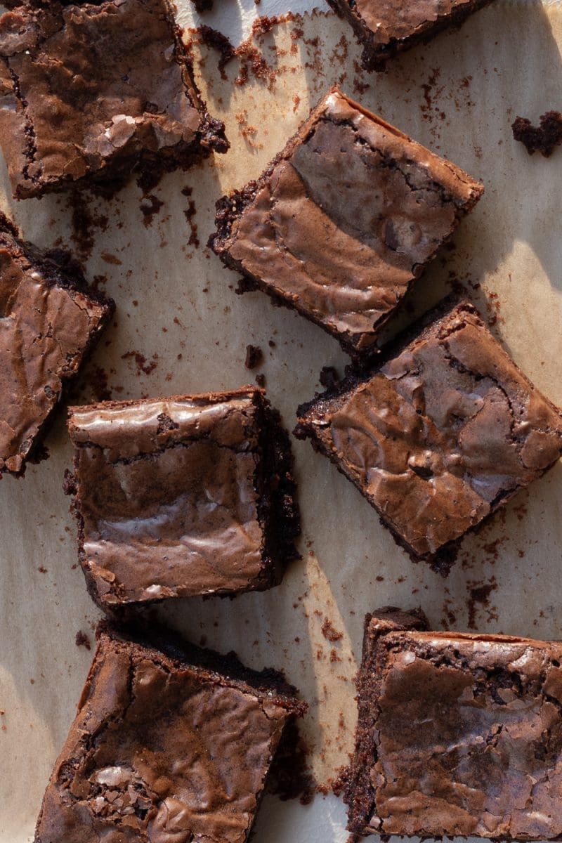 The sliced small batch fudge brownies scattered on parchment paper.