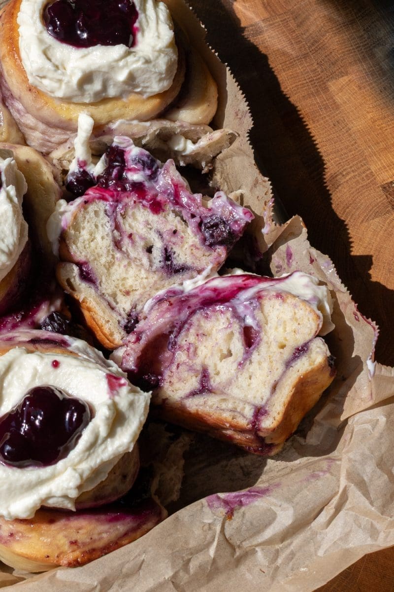The milk bread blueberry sweet rolls with one cut in half.