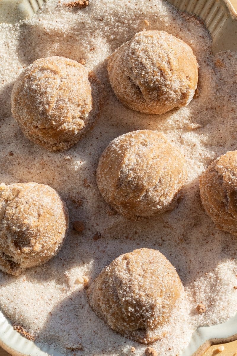 Coating the dough balls in nutmeg sugar.