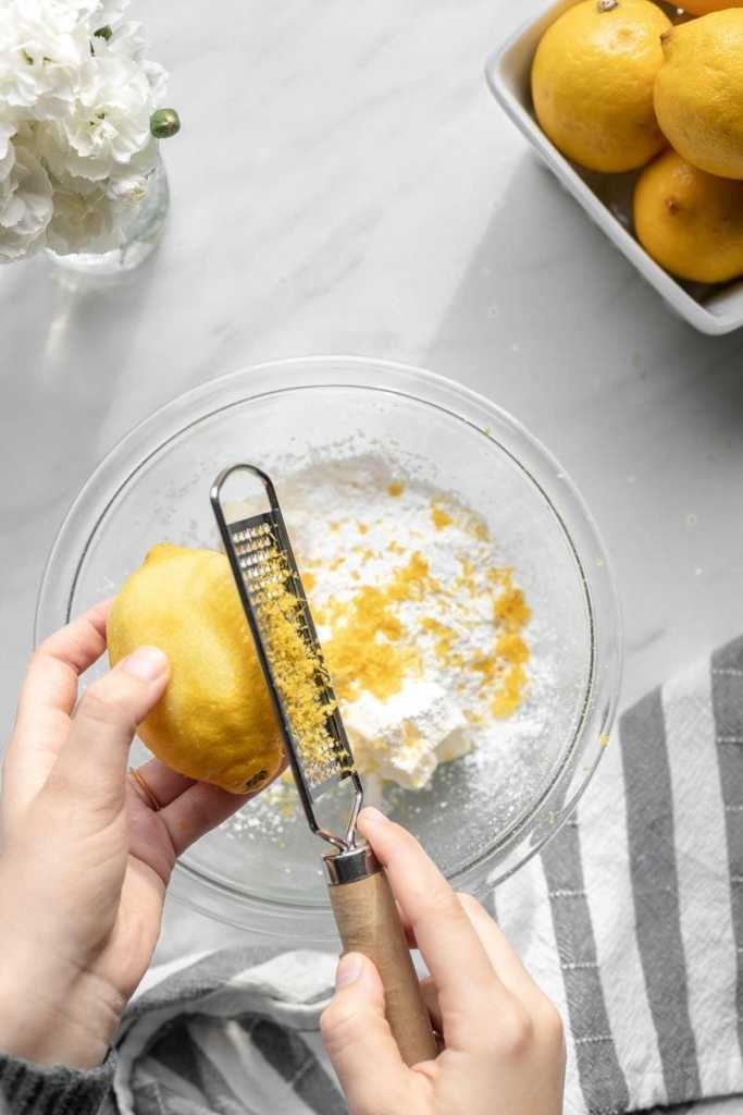 Zesting the lemon into the powdered sugar.