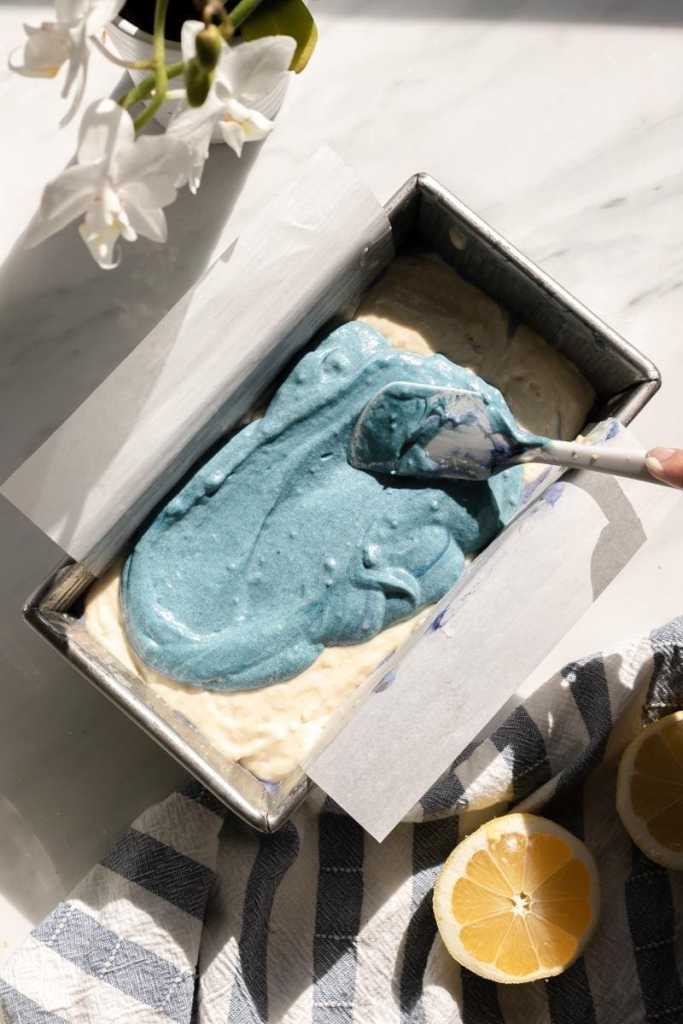 Spreading the butterfly pea powder blue cake batter on the loaf cake.