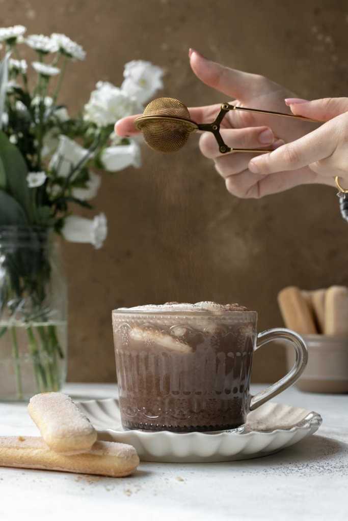 Dusting the mascarpone whipped cream with cocoa powder.