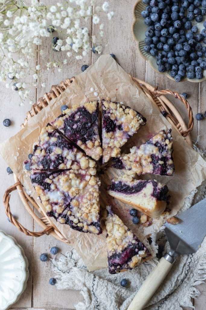 Flat lay image of the blueberry brioche crumb cake on a tray, sliced up.