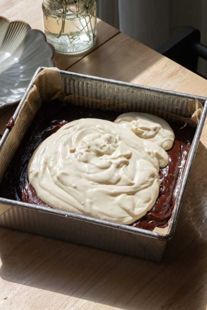 The cheesecake batter poured on top of the brownie batter.