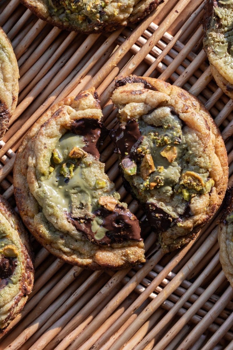 Close up of a pistachio cream chocolate chip cookie cut in half.