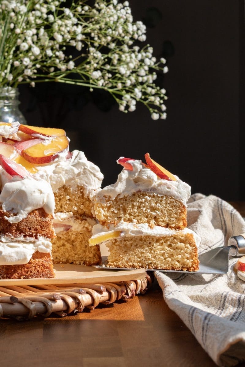 A slice of peach shortcake cake being pulled from the cake.