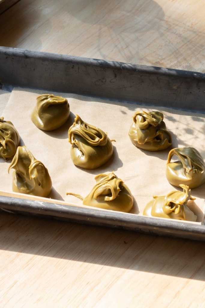 Small scoops of pistachio cream on a tray.