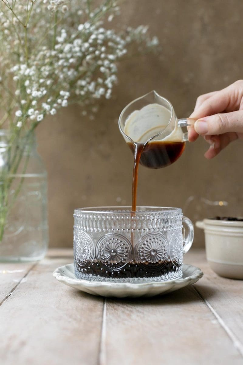Pouring espresso into a coffee cup.