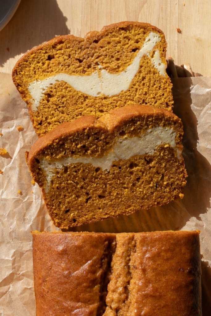 Close up of two slices of cream cheese swirl pumpkin bread.