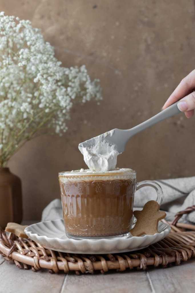 Topping the drink with whipped cream.