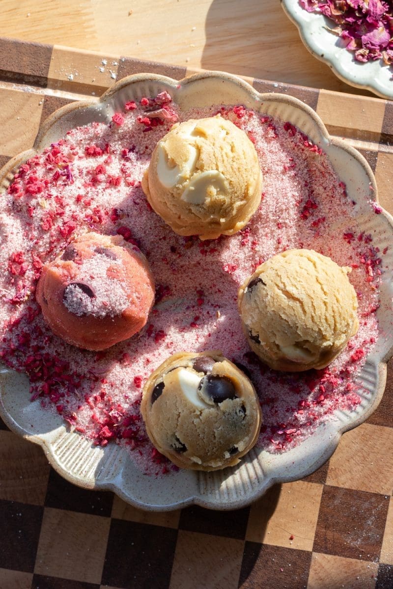 Rolling the cookie dough in raspberry rose sugar.