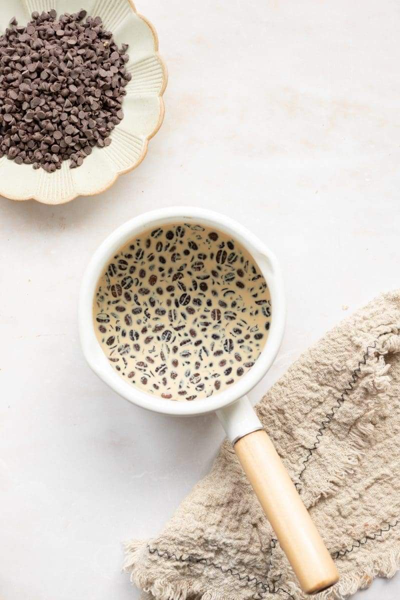 Espresso beans in milk in a saucepan.