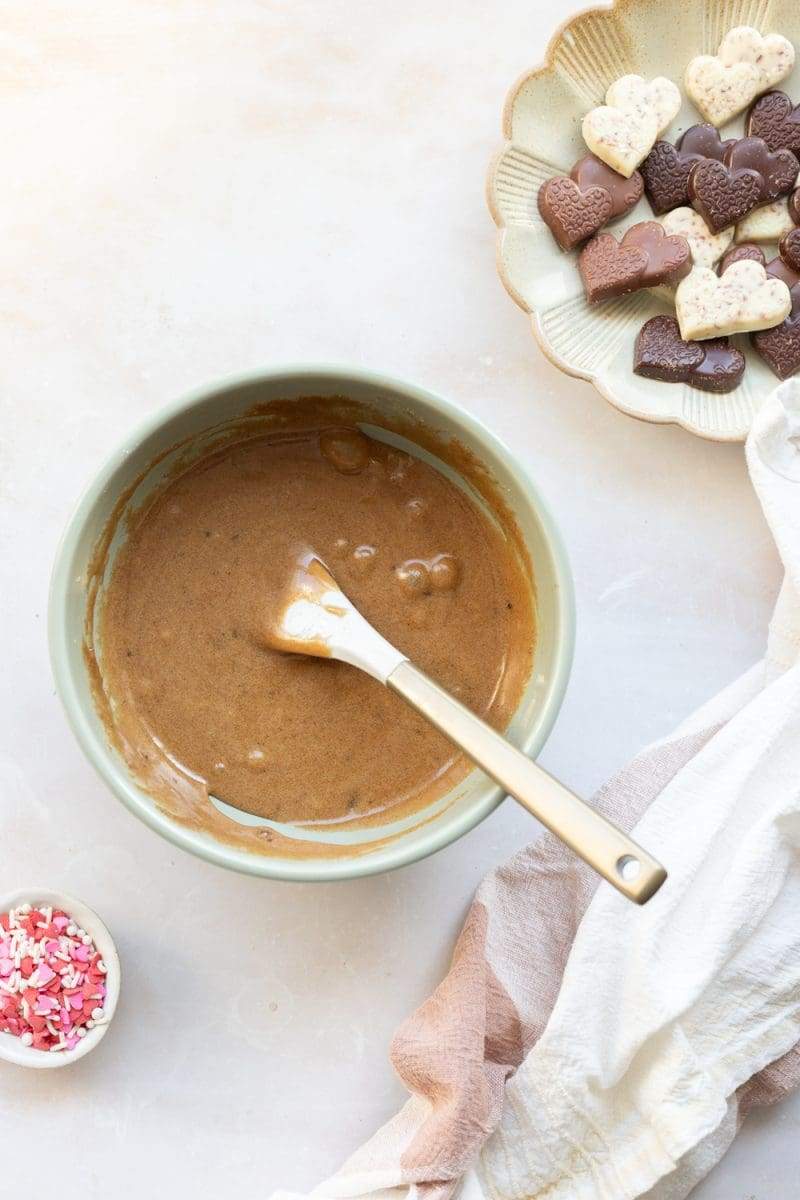 The cookie dough in a mixing bowl with the butter, sugars, egg and vanilla mixed in.