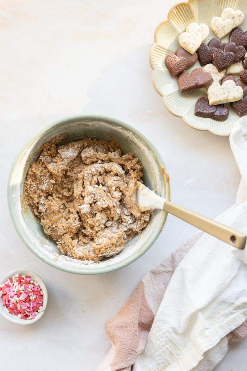 The cookie dough in a mixing bowl with the dry ingredients mixed in until only a few streaks of flour remain.