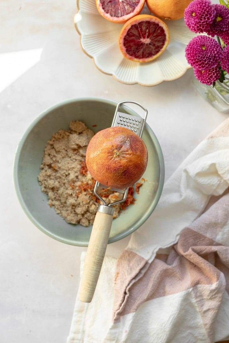 zesting the blood orange into the mixing bowl