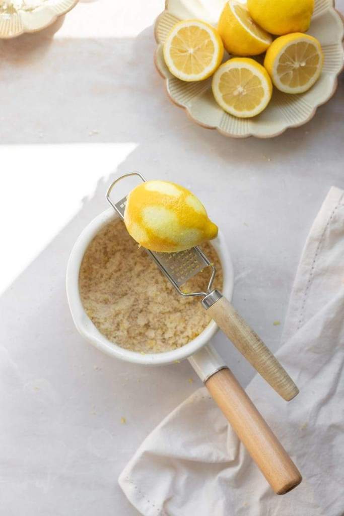 a saucepan with a zester sitting on top of it along with a zested lemon