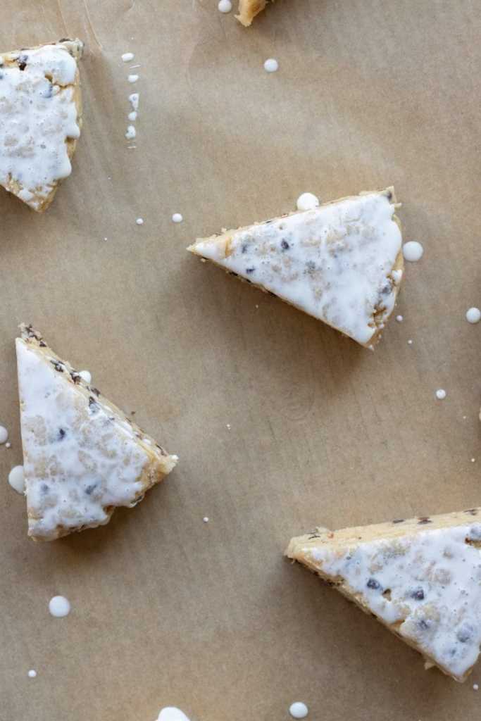 The sliced scones on a baking sheet, brushed with heavy cream.