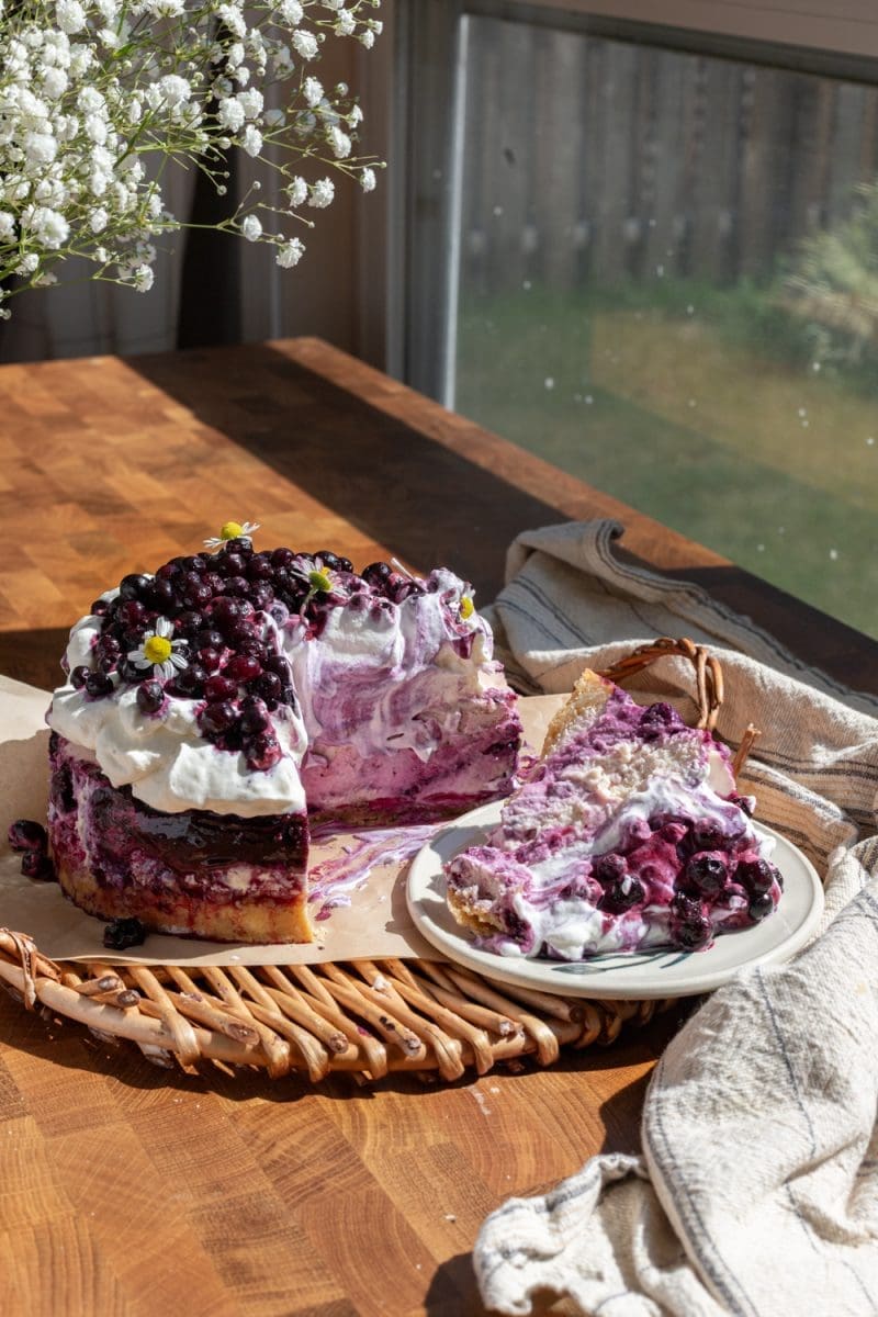 The wild blueberry cheesecake sliced on a serving tray.