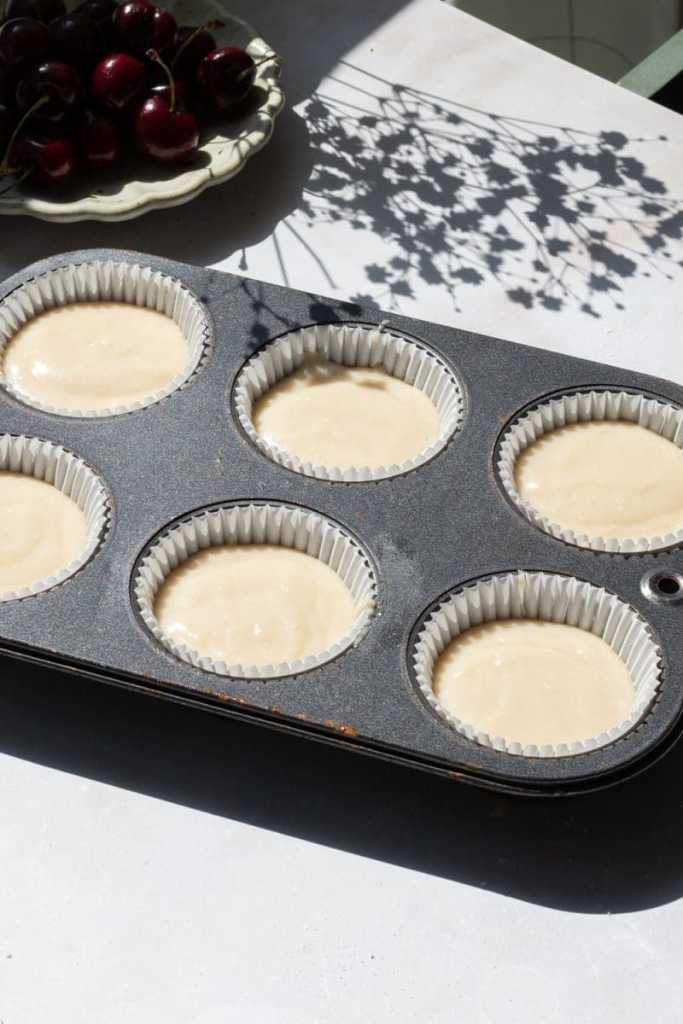 The cupcake batter divided between the parchment liners.