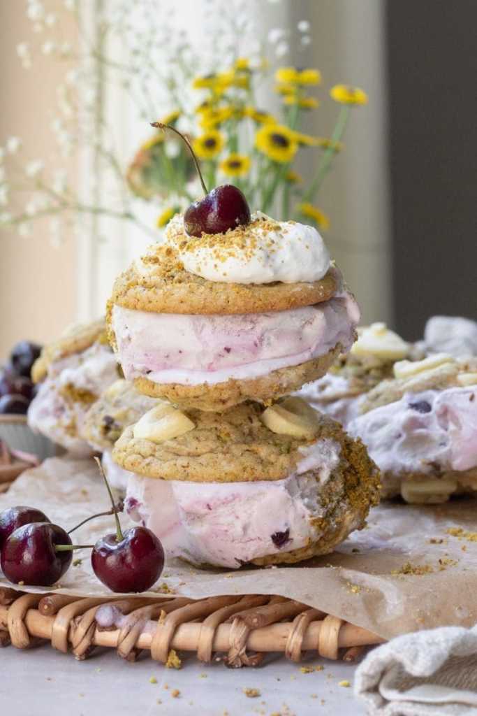 Two pistachio cookie ice cream sandwiches stacked on one another.