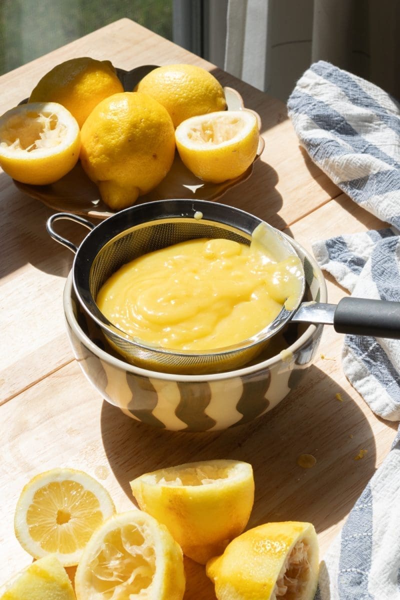 Pouring the lemon curd through a fine mesh sieve.