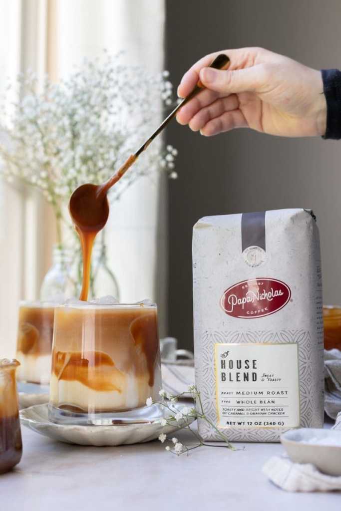 The macchiato next to a bag of coffee.