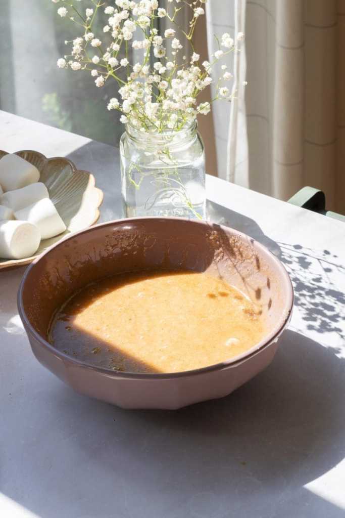 Mixing bowl with the brown butter, sugars, egg and vanilla mixed together.