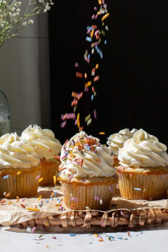Sprinkles falling on to one of the confetti cupcakes.