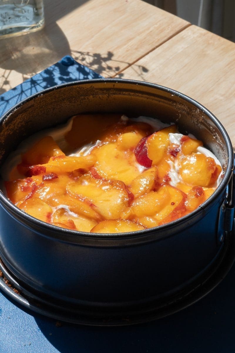 Layering the mascarpone and fresh peaches on to the cake.