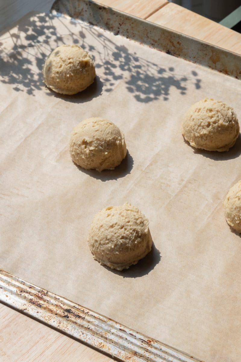 The scooped out cookie dough on a baking tray.