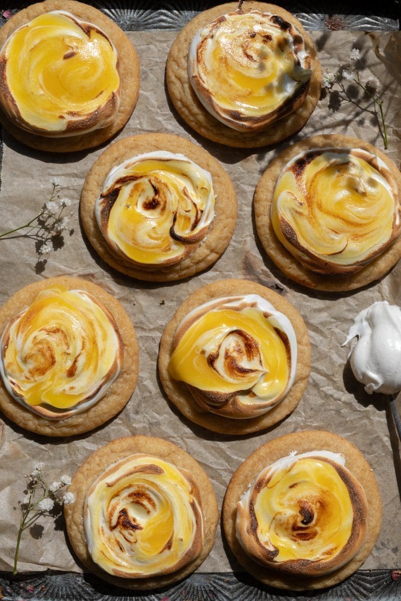 Lemon meringue pie cookies spread out on a tray.