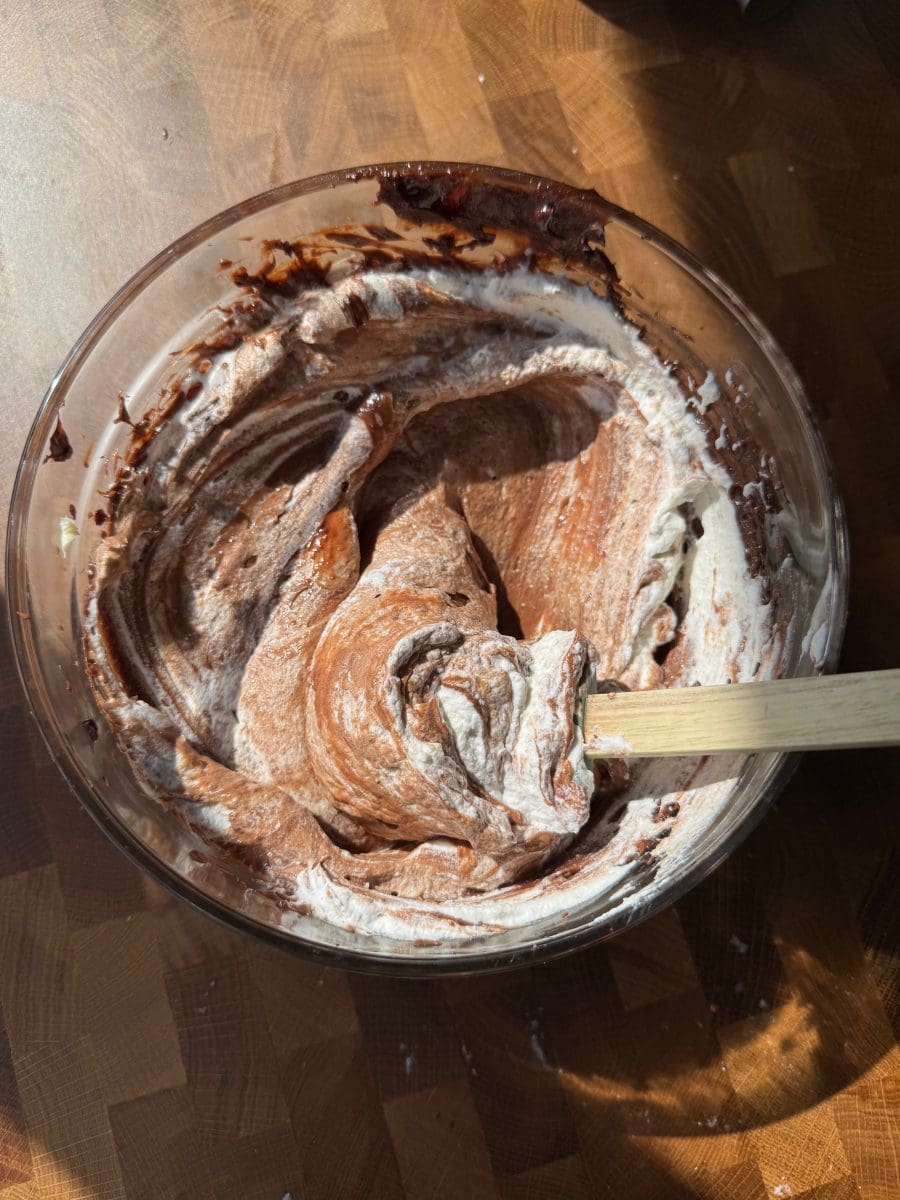 Folding whipped cream into the pie filling.