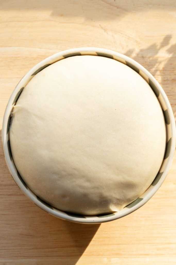 The risen brioche dough in a bowl.