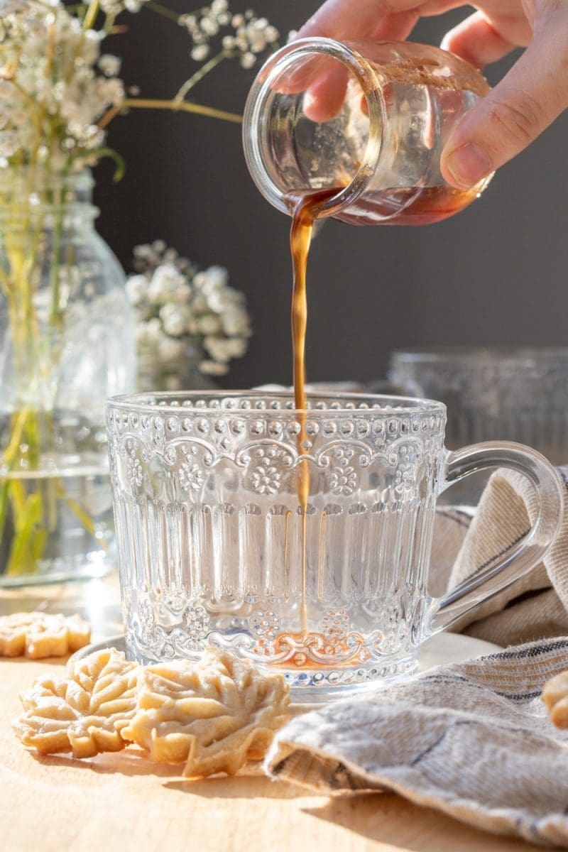 Pouring syrup into the coffee cup.