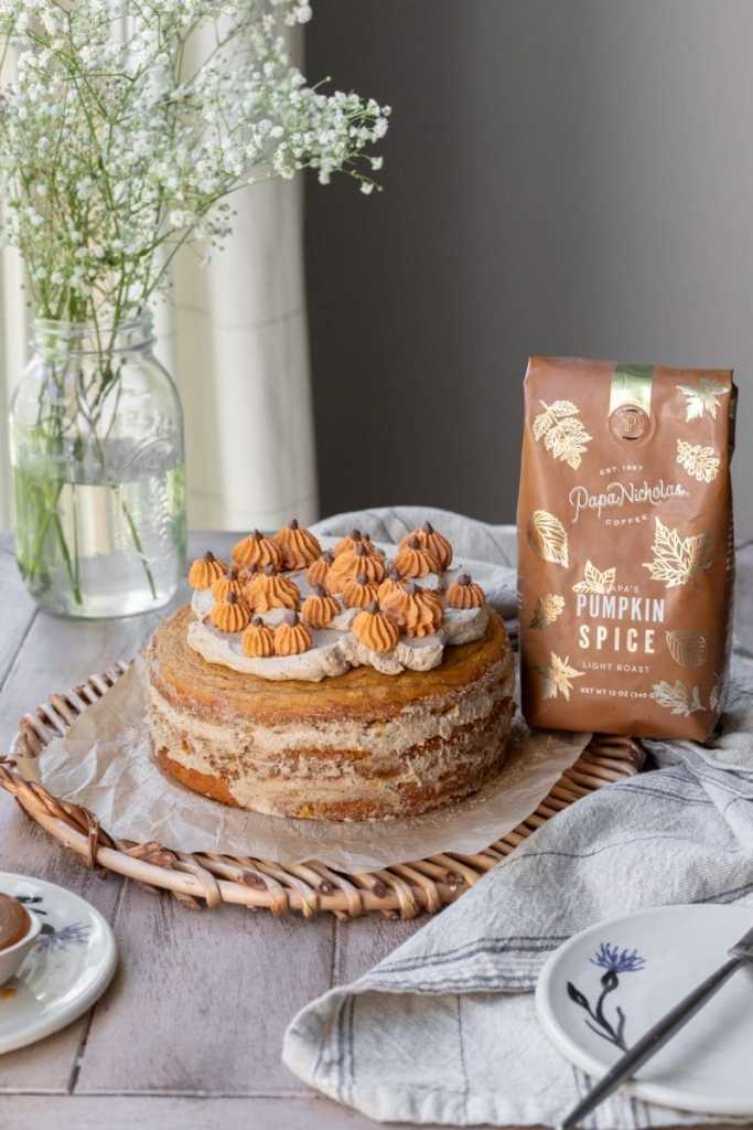 A bag of coffee next to the caramel pumpkin spice latte cake.