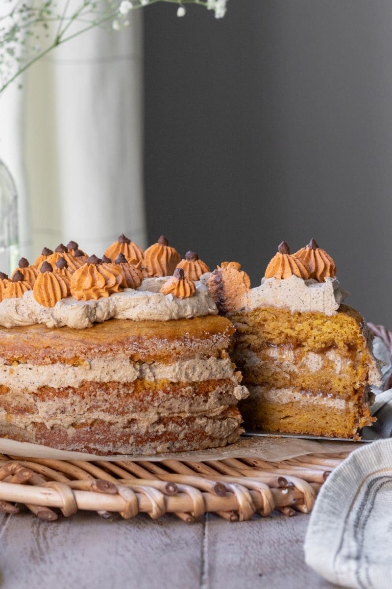 A slice of caramel pumpkin spice latte cake being pulled from the whole cake.