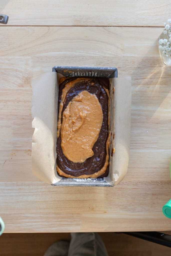 The pumpkin and chocolate batters layered on top of each other in a loaf pan.