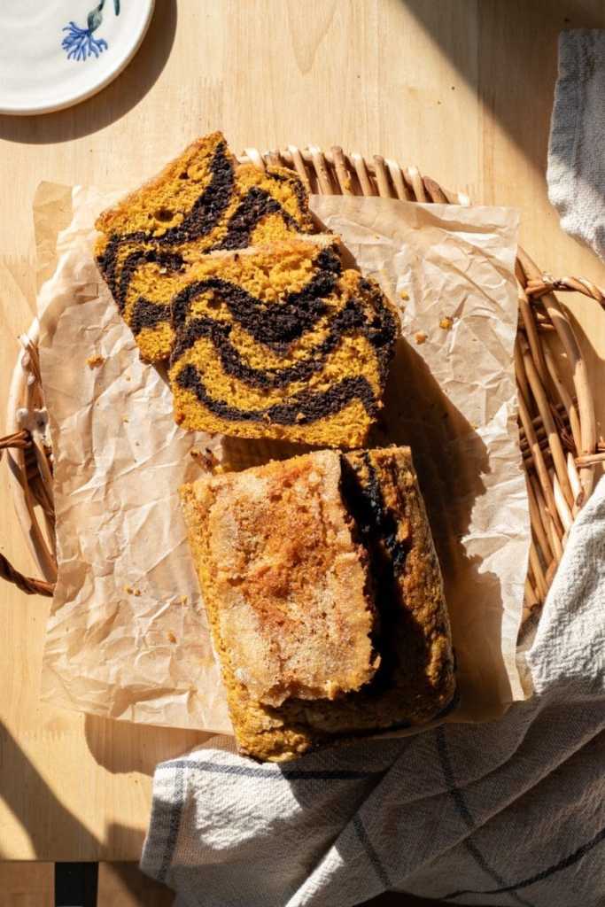 Slices of the chocolate marbled pumpkin bread next to the loaf.