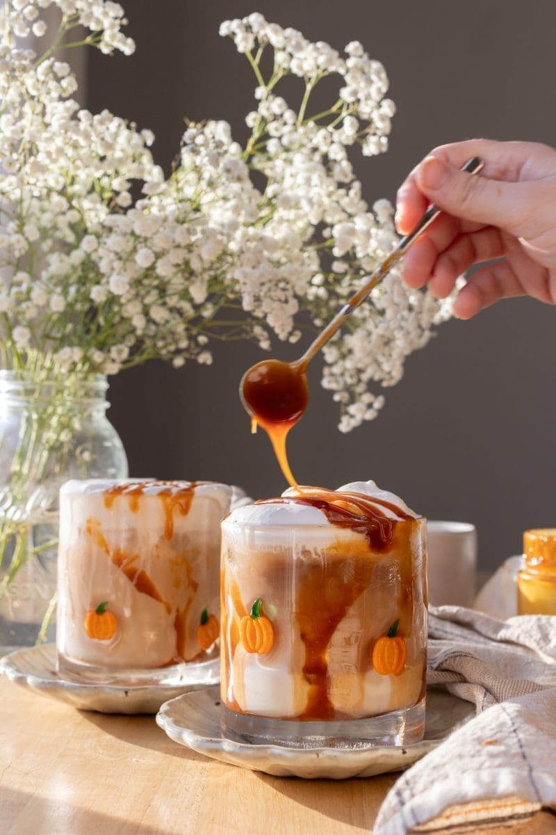 Drizzling caramel over an iced caramel chai latte.
