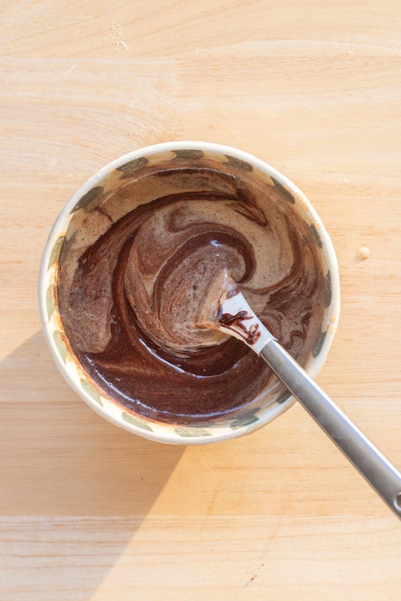 Folding the chocolate mixture into the egg mixture.