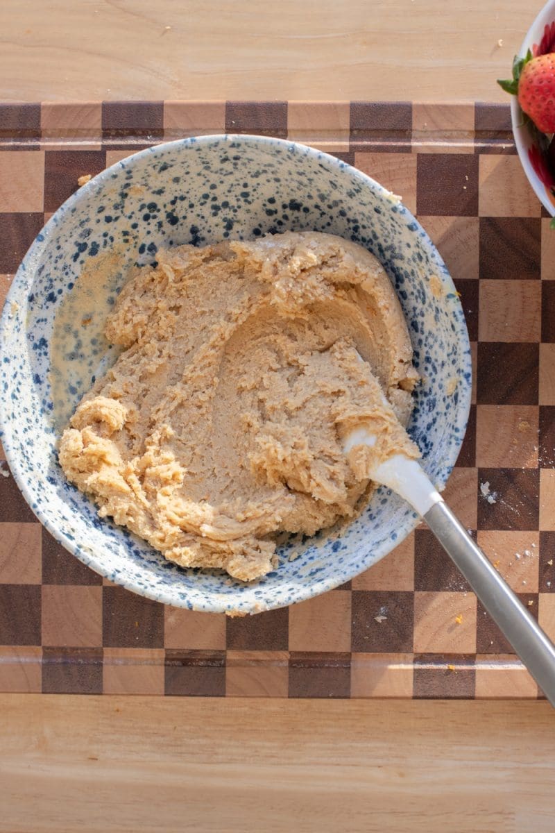 The finished orange brown sugar cookie dough in a mixing bowl.