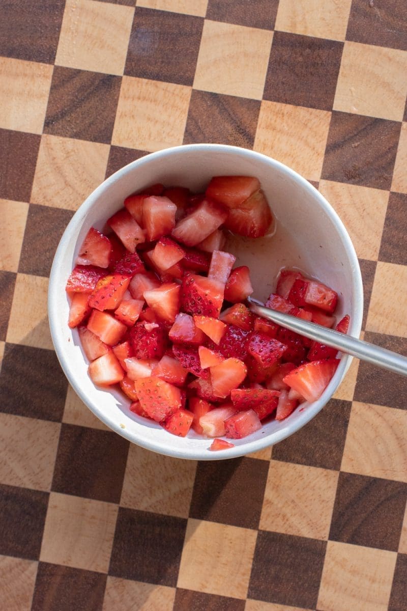 Macerated strawberries in a small mixing bowl.