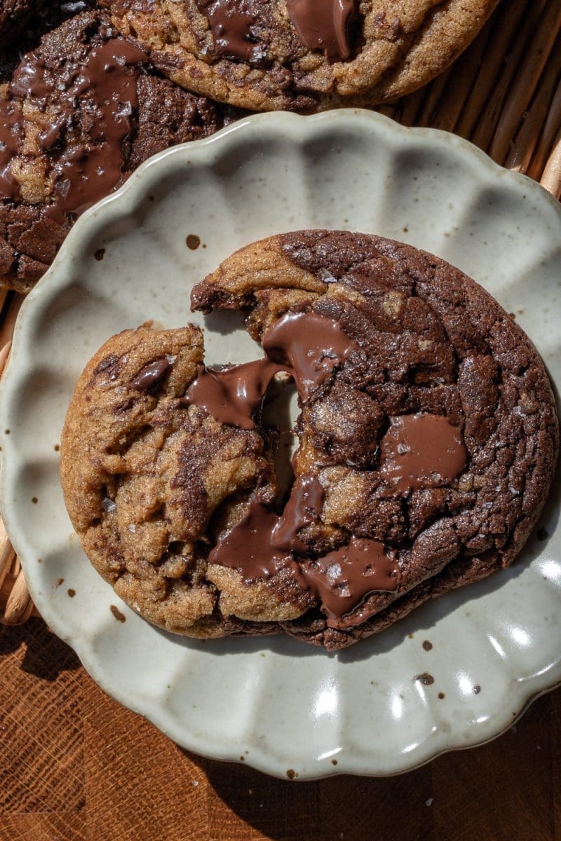 Close up of one of the espresso brownie chocolate chip cookies that has been broken in half.