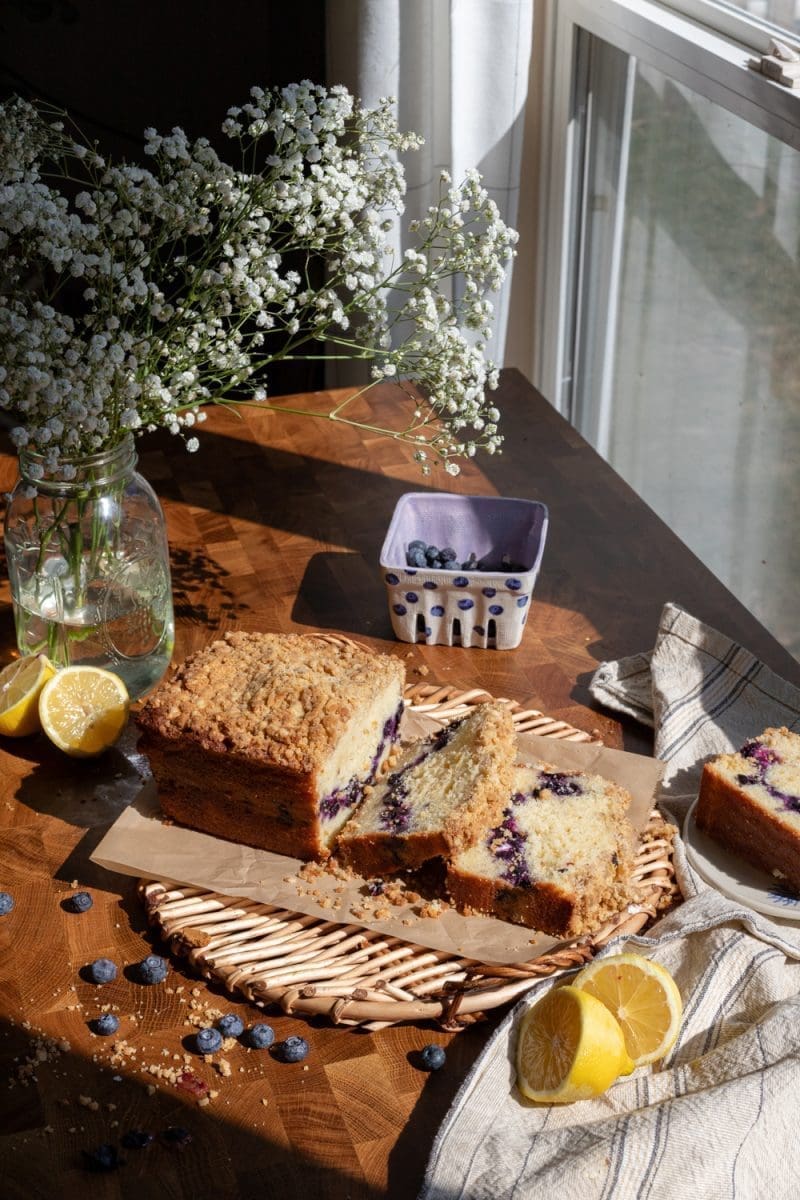 Stylized view of the sliced lemon blueberry loaf on a serving tray.