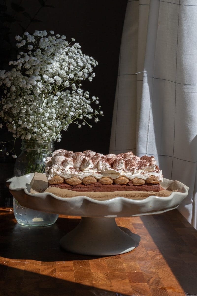 The full loaf of small batch tiramisu brownies on a cake stand.