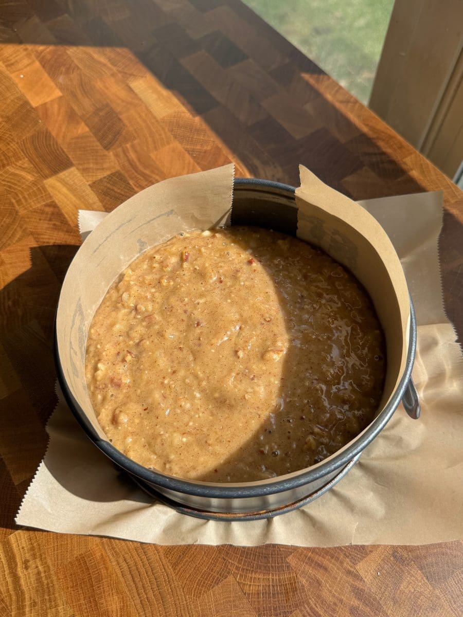 Cake batter in a lined springform pan.
