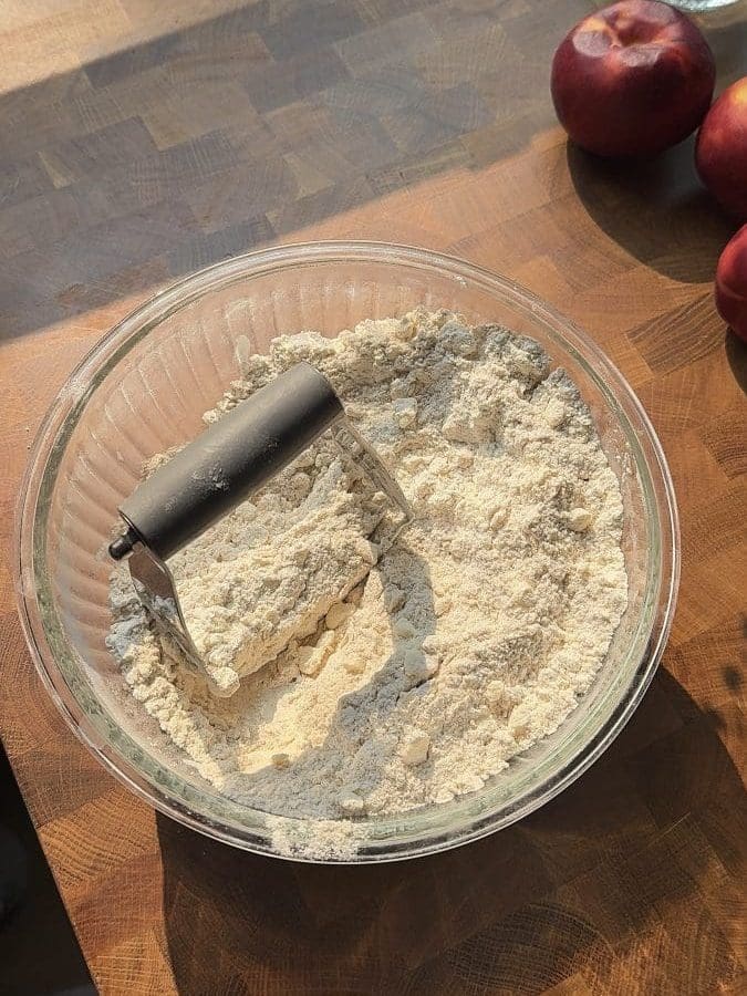 Using a pastry blender to cut the butter into the flour.