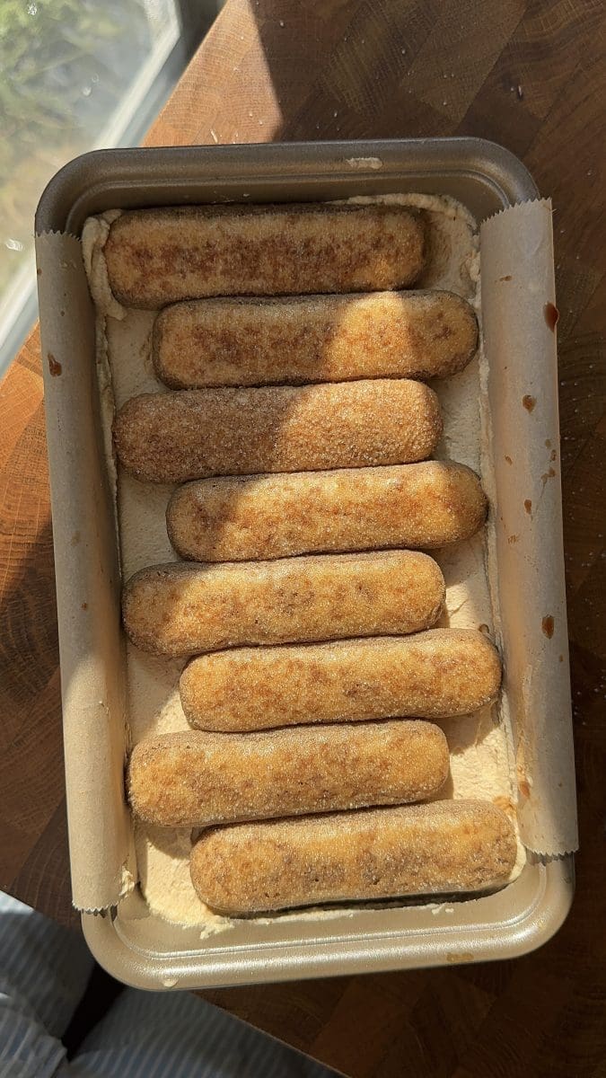 Layering the tiramisu in a loaf pan.